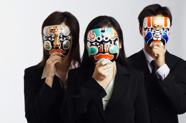 Close-up of two businesswomen and a businessman wearing masks --- Image by © Redchopsticks/Corbis